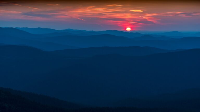The sun is setting over a mountain range
